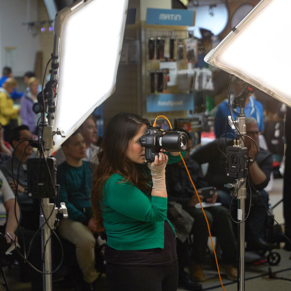 Image of woman holding camera in front of audience