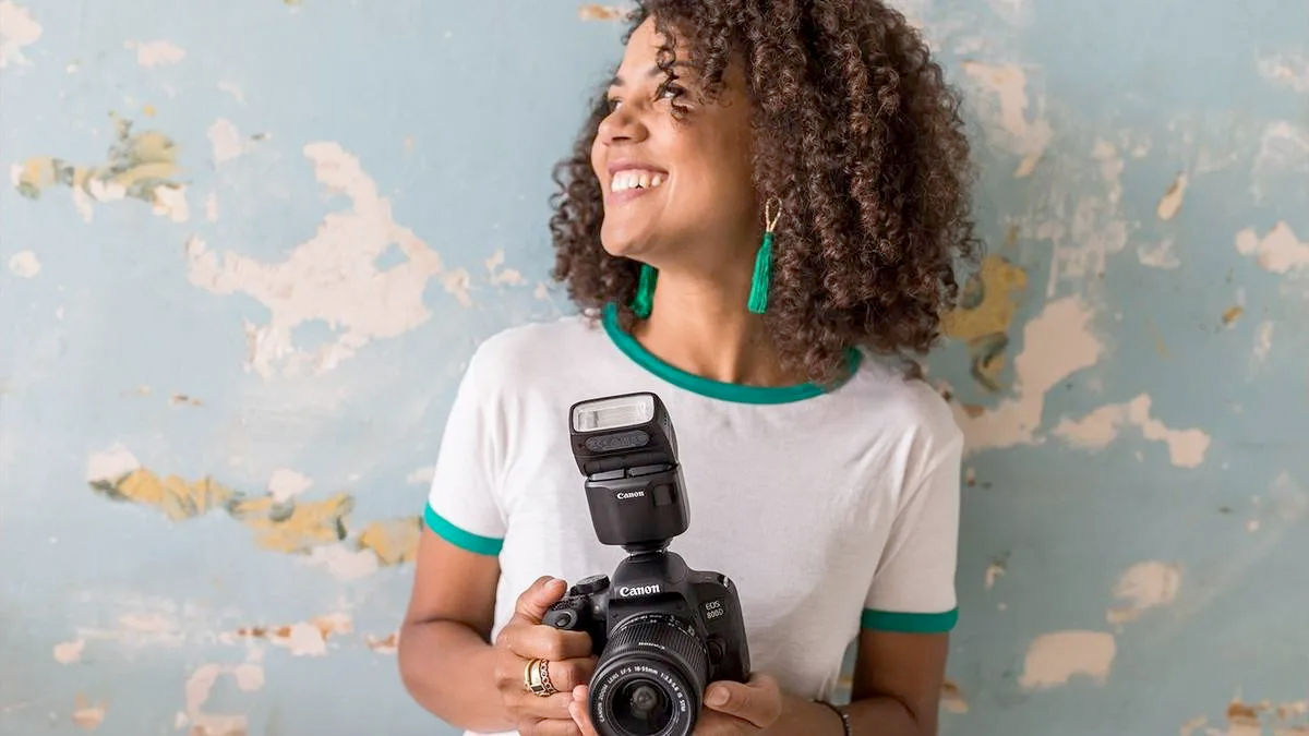 Smiling Ldy holding Canon Camera