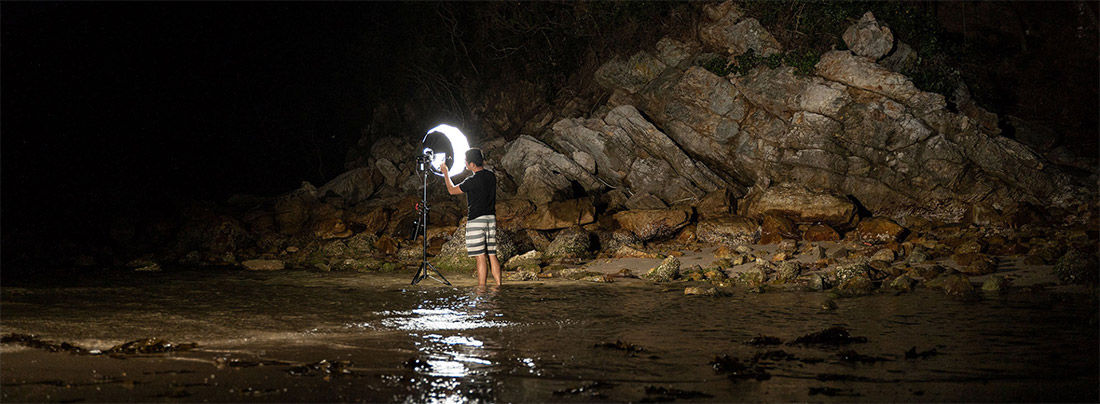 Image of photographer using softbox at night, lighting up scene